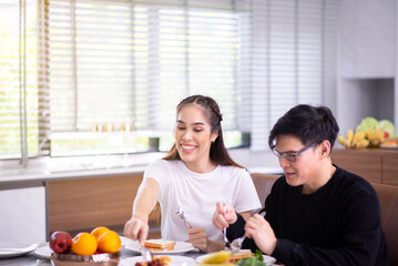 Happy lover asian couple in love eating food together in dining room