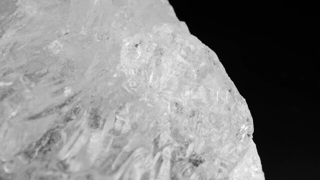 Clear white quartz crystals glistening against a dark background, captured through smooth motorized slider panning and macro lens for intricate details.