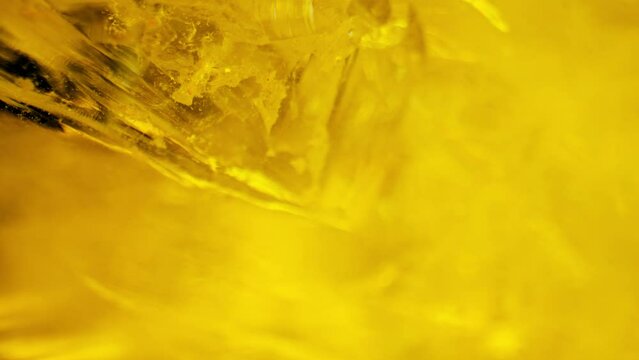 Crystal clear quartz glistening under yellow light, captured through smooth panning and macro lens for mesmerizing details.