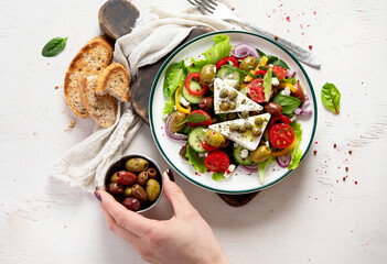 Greek village salad horiatiki with feta cheese, olives, cherry tomato, cucumber and red onion, vegeterian mediterranean food, low calories dieting meal.