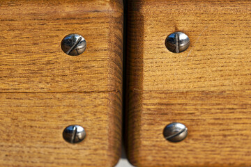Close up of wooden back rest of bench with metal screws at bus station at City of Zürich district Schwamendingen on a sunny winter day. Photo taken January 31st, 2023, Zurich, Switzerland.