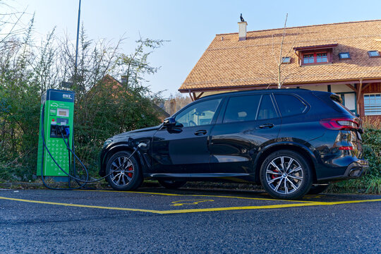 Parked BMW SUV charging battery at charging station of power supply company EWZ at City of Z&uuml;rich district Schwamendingen on a sunny winter day. Photo taken January 31st, 2023, Zurich, Switzerland.