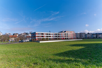 Fototapeta na wymiar Scenic view of beautiful modern red and gray senior residence at City of Zürich district Seebach on a sunny winter day. Photo taken January 31st, 2023, Zurich, Switzerland.