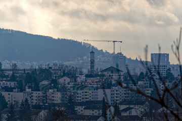 Skyline of City of Zürich on a cloudy winter noon seen from hill at district Seebach. Photo taken January 31st, 2023, Zurich, Switzerland.