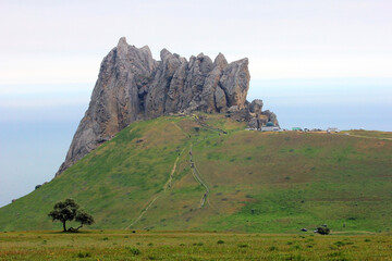 Fototapeta na wymiar Pilgrims climb the sacred mountain Beshbarmag.