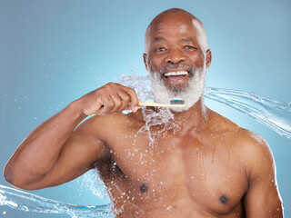 Fototapeta na wymiar Portrait, water splash and black man with toothbrush, toothpaste or dental hygiene for wellness, brushing and blue studio background. Senior African American male, guy and clean teeth for oral health