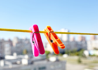 Colorful clothespins against the blurred background. Plastic clothespins in different colors. Blurred image, selective focus