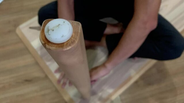 Unidentified asian man unscrewing and uninstall wooden table leg. Home appliance and furniture concept 