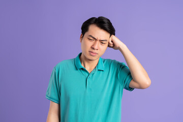 portrait of asian man posing on purple background