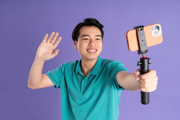 portrait of asian man posing on purple background