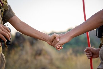 Close-up photo of school boy scouts Handshake with left hand Scout greeting or congratulation Scouts handshake have good teamwork in the camp