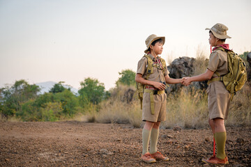 Fototapeta premium Asian boy scout schoolgirl handshake greeting Boy Scout or Congratulations Scouts holding hands have good teamwork in the camp.