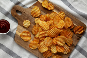 Barbeque Potato Chips on a wooden board, top view. Flat lay, overhead, from above.