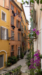Fototapeta na wymiar Old town street flowers in alley facade building architecture of Nice on French Riviera
