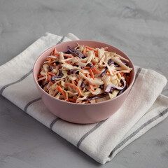 Homemade Classic Southern Coleslaw in a pink Bowl, low angle view.