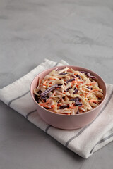 Homemade Classic Southern Coleslaw in a pink Bowl, side view. Copy space.