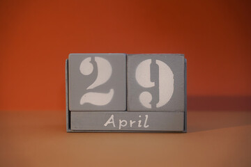 29 April on wooden grey cubes. Calendar cube date 29 April. Concept of date. Copy space for text or event. Educational cubes. Wood blocks in box with date. Selective focus blurred background