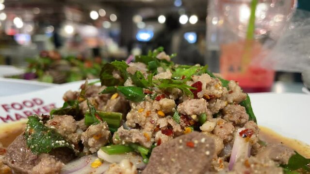 Spicy minced pork salad (Larb Moo) on plate close up shot inside food court, Food and drink concept, Hua Hin, Thailand