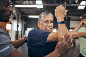 Fotobehang Persoonlijk Elderly man, gym and stretching with personal trainer for health, wellness and training with smartwatch. Men, workout motivation and exercise together for goals, muscle development or body healthcare  © S Fanti/peopleimages.com