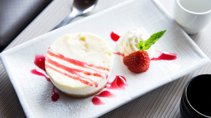 Cheesecake with red fruit sauce and fresh fruit such as raspberries, blueberries or strawberries.