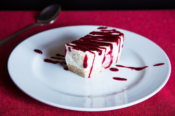 Cheesecake with red fruit sauce and fresh fruit such as raspberries, blueberries or strawberries.
