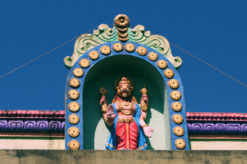 Narasimha is a Hindu god in the form of a man-lion on the roof of a temple in India.