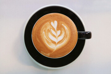 Top view of mouthwatering frothy cappuccino coffee with beautiful latte art