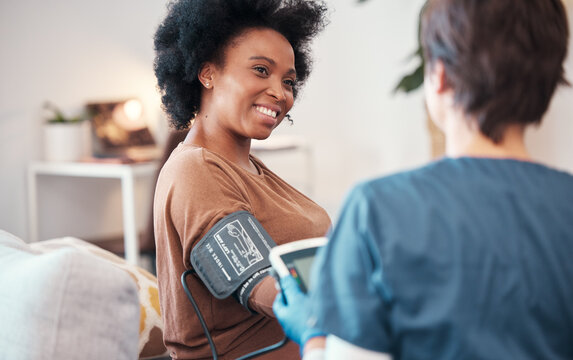 Black woman, healthcare and checkup with caregiver in bedroom checking, blood pressure or pulse at home. Happy African American female patient or visit from medical nurse monitoring heart in wellness