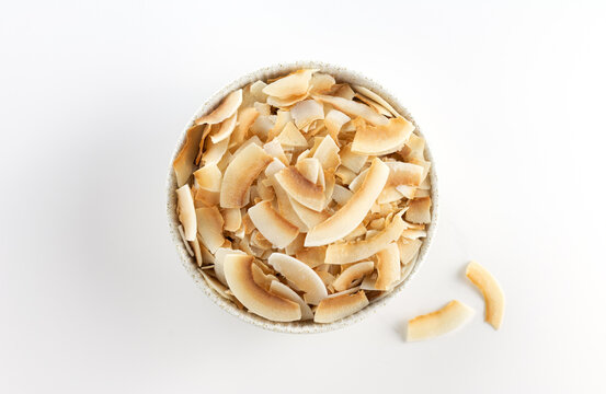 Coconut chips or coconut flakes on a white background. Healthy snacks. Coconut dessert. Top view.