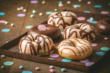 Chocolate Donuts, Berliner, Krapfen on a rusty tray on dark wooden background