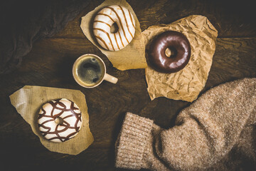 Chocolate donuts and coffee on a dark wooden table, cozy scene of a coffee break, top view