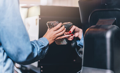 Close up QR code scan payment at coffee shop via smart phone technology.