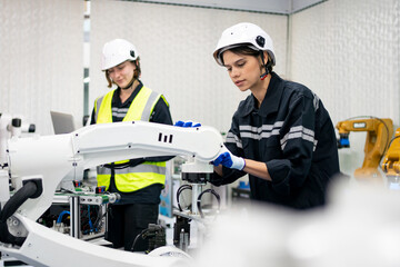 Professional young industrial factory woman employee working with machine parts putting, checking and testing industrial equipment