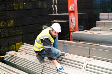 portrait of a worker in metal material pipe warehouse.