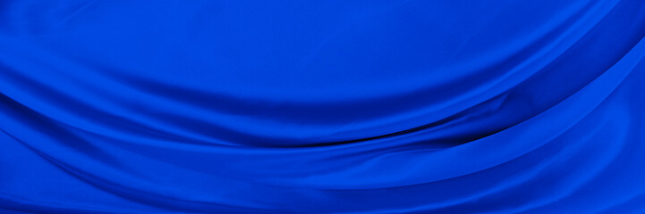 Black blue satin dark fabric texture luxurious shiny that is abstract silk cloth background with patterns soft waves blur beautiful.