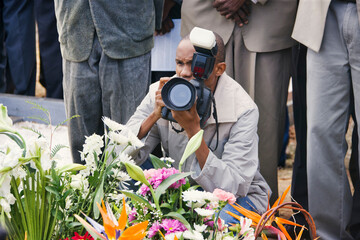 african photographer taking pictures at a funeral