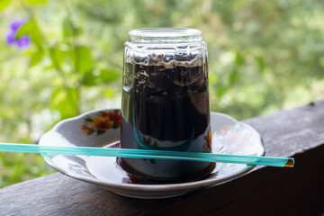 upside down coffee served in an upside down glass typical Indonesian with a blurry background