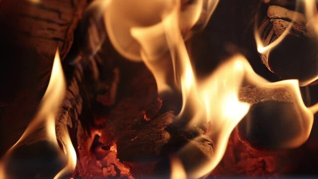 Fire burns in wood burning stove of country house.