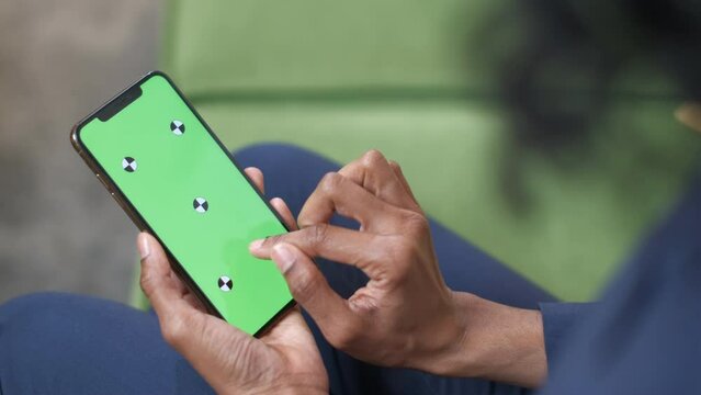 A black woman with a smartphone in her hand. Touch screen gestures: Tap, Swipe, Pinch, Spread. Image zoom. Officework. The concept of a successful business woman, feminism. Close-up. Green screen