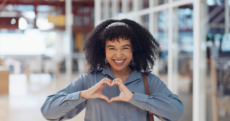 Hands, heart and love with a business black woman making a hand gesture alone in her office at work. Happy, smile and positive with a female employee gesturing a hand sign for romance or affection