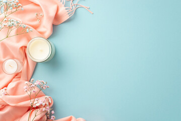 Hello spring concept. Top view photo of candles in glass holders gypsophila flowers and pink plaid...