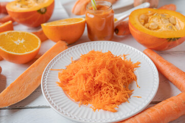 Orange colored vegetables and fruit on white background. Closeup and front view