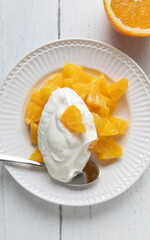 Fototapeta premium Fruit dessert or snack with chopped oranges and islandic skyr. 