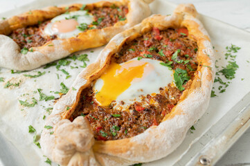 Turkish pide with minced meat filling  and egg