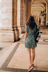 A beautiful woman walks with backpack in Turin, Italy.