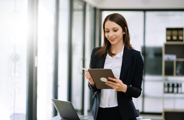 Confident female entrepreneur looking at the camera while standing. Young businesswoman standing in the boardroom of a modern office..