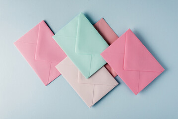 Collection of envelopes in pastel colors on a light blue background.