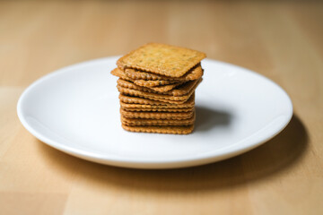 Homemade thin crispy crackers on white plate, Selective Focus.