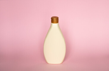 Blank beige bottle for shower gel, shampoo, lotion, cream, soap, gel on pink background. Beauty product and body care cosmetics.