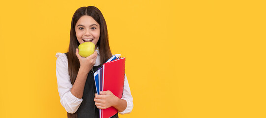 Being hungry for new knowledge. Happy schoolchild eat apple. Portrait of schoolgirl student, studio banner header. School child face, copyspace.